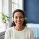 Portrait of a smiling woman in her early 30s, looking at the camera with a happy expression.